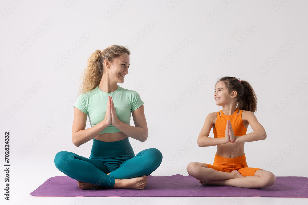 mother and daughter do sports and gymnastics on a white background, two girls do fitness mother and daughter do sports and gymnastics on a white background, two girls do fitness