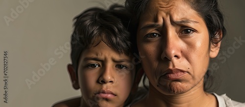 Hispanic mother and son standing together disgusted expression displeased and fearful doing disgust face because aversion reaction. with copy space image. Place for adding text or design photo