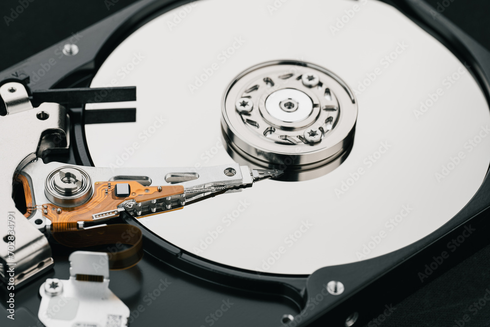 Hard drive isolated on white background. HDD. Major components of a 3.5-inch SATA hard disk drive: platter, spindle, actuator, actuator arm. Disk head above the plates Hard drive isolated on white background. HDD. Major components of a 3.5-inch SATA hard disk drive: platter, spindle, actuator, actuator arm. Disk head above the plates
