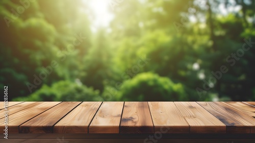 Mock up empty wood table texture on blur fresh green pine garden background behind clear glass window. Template of brown wooden desk. Blank space at vintage wood background, for product advertise.