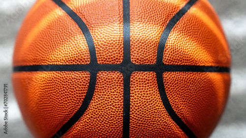 Close-up of a textured basketball surface with a clear black line, shot against a blurred grey background.