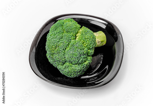Fresh green broccoli in a black bowl on a white background, top view. A healthy diet.