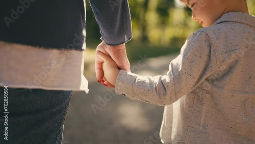 Mother and little son holding hands in park, parent child relationship, adoption photo