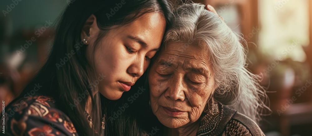 Asian daughter comforting elderly mother with mental illness - obrazy, fototapety, plakaty 
