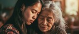 Asian daughter comforting elderly mother with mental illness