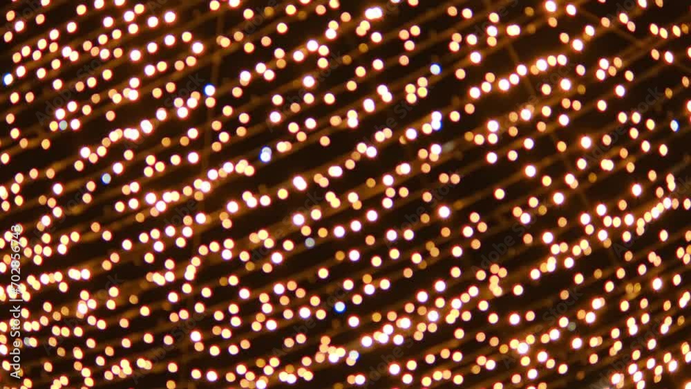 Shimmering golden garland. Shining Christmas decoration. Blurred bokeh light. Golden light on a dark background. Christmas illumination. Animated abstract glowing background. Festive mood Shimmering golden garland. Shining Christmas decoration. Blurred bokeh light. Golden light on a dark background. Christmas illumination. Animated abstract glowing background. Festive mood