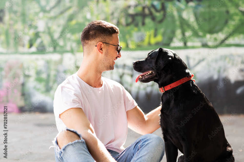 Guy in sunglasses hugs his dog in autumn park Guy in sunglasses hugs his dog in autumn park