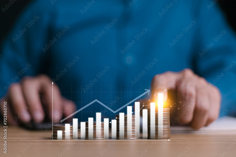 Investment and financial concept, businessman hand with money coin stacking and push arrow up to make a financial growth and profit, interest rates and dividends, investment returns, income, saving. - obrazy, fototapety, plakaty 