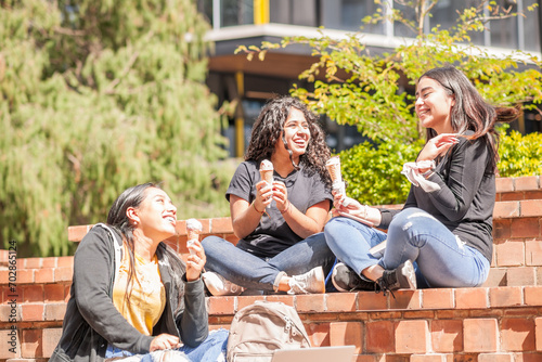 Under the sun, 3 girls enjoying a delicious cream ice cream.