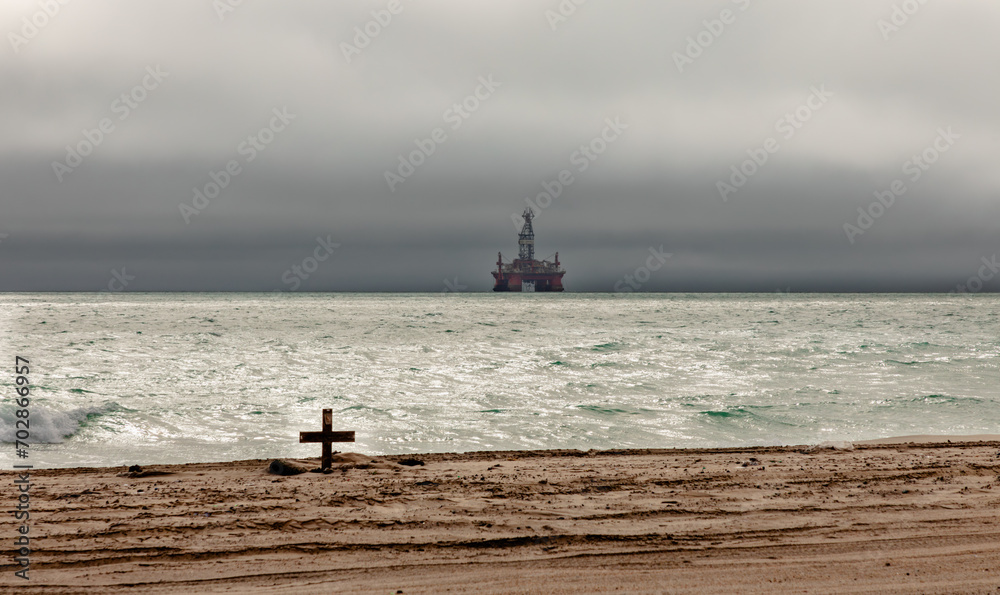 An oil rig looms amid threatening skies over the Atlantic Ocean off the Namib desert coast of Namibia.