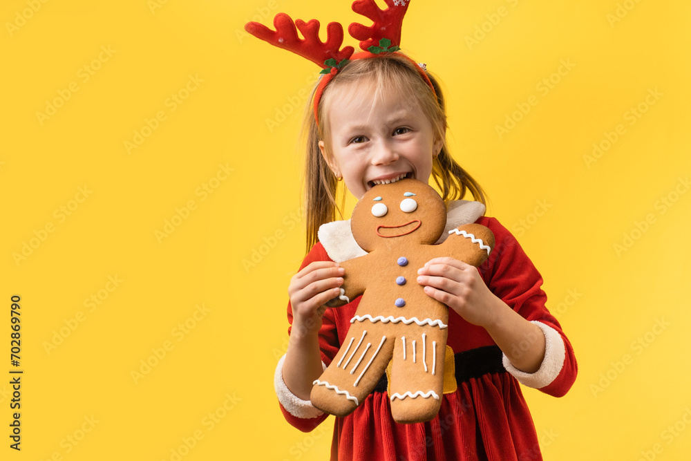 Cute little girl wearing Santa red costume and holding big baked