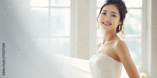 A radiant Asian bride in a beautiful white wedding dress, exuding joy and elegance in a stylish and romantic setting.