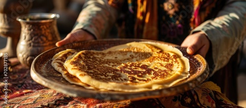 Hand holding a Moroccan pancake, baghrir, common in Moroccan breakfasts. photo