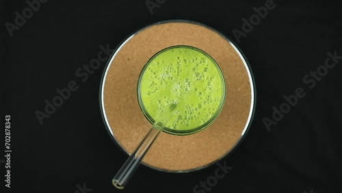 Top View Rotating display of avocado juice on black background. photo