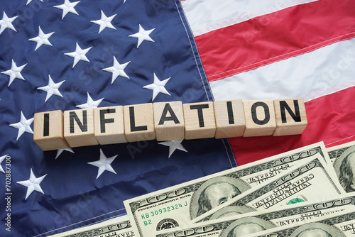 Inflation in the USA. The US flag with cubes with the inscription - inflation. American economy and business concept. Effect of recession on US economy