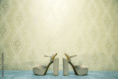 Par de sapatos de salto alto na mesa azul e fundo de papel de parede vintage 