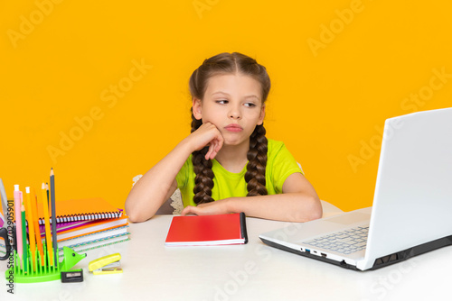 Fotografi A disgruntled girl is doing her homework at her desk