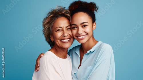 Joyful charming enjoyable content senior mother with grown-up daughter two ladies together in casual attire embracing embrace gaze at camera