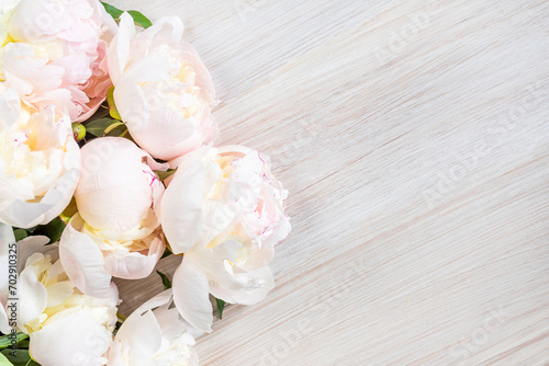 Delicate pale peonies on a white wooden table. Copy Space © LariBat