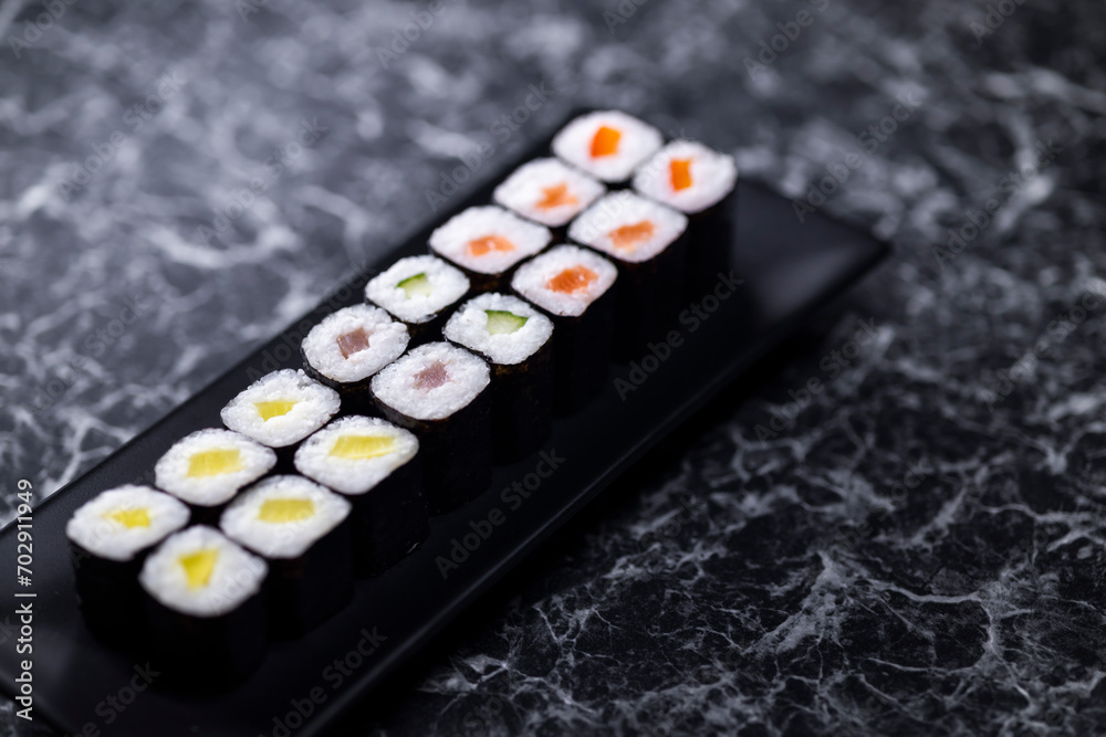 set of sushi rolls with seafood on a black stone background set of sushi rolls with seafood on a black stone background
