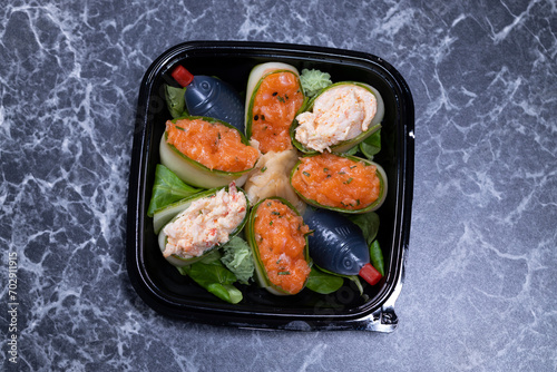 set of sushi rolls with seafood on a black stone background