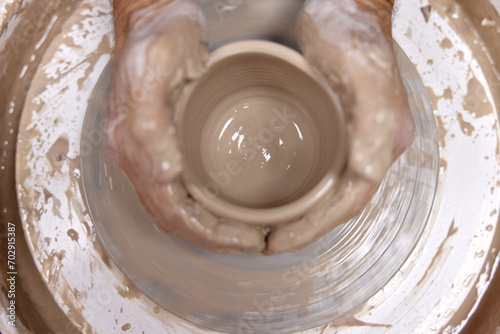 male hands making ceramic cup on pottery wheel, Close-up, top view