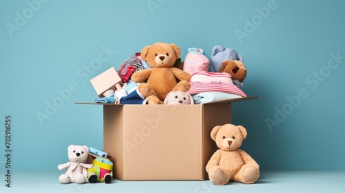 Charitable Donations Box. Toys, Books, Clothing for Aid, Top View on Light Blue. Supporting Low-Income Families, Decluttering, Online Sale, or Relocation Assistance.