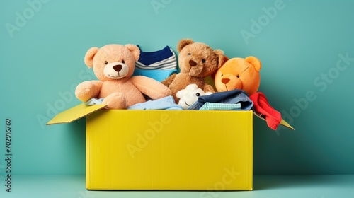 Charity Donation Box. Toys, Books, Clothing on Light Blue Background. Aiding Low-Income Families, Decluttering, Selling Online, and Relocating Assistance photo