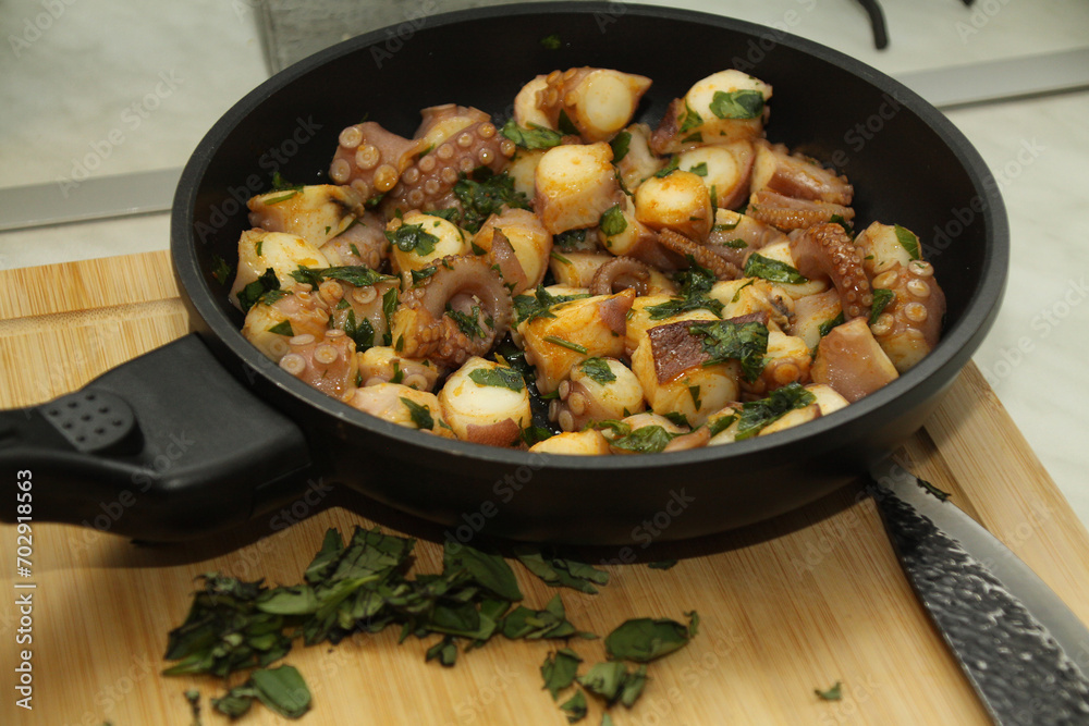 close up of a pan with seafood, tubes, squid, herbs, close up of a pan with seafood, tubes, squid, herbs,