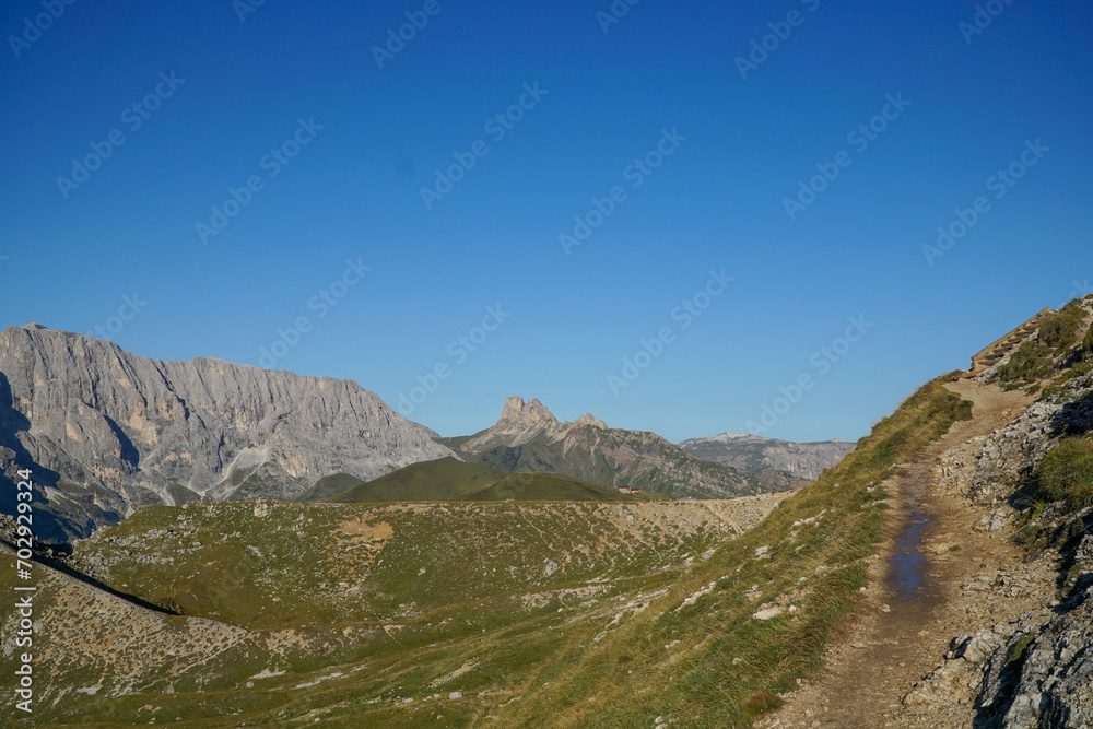 Young sporty female hiker on idyllic trail in awesome dolomite mountain landscape. Hiking near Gardena Valley and Rosengarten Schlern Naturepark in South Tyrol, Italy
