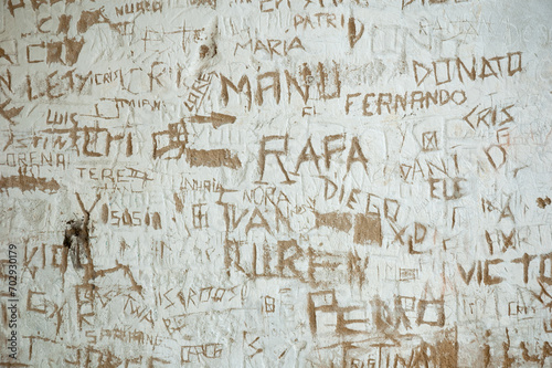 Grafiti con nombres de niños escritos en una pared de un pueblo en España.