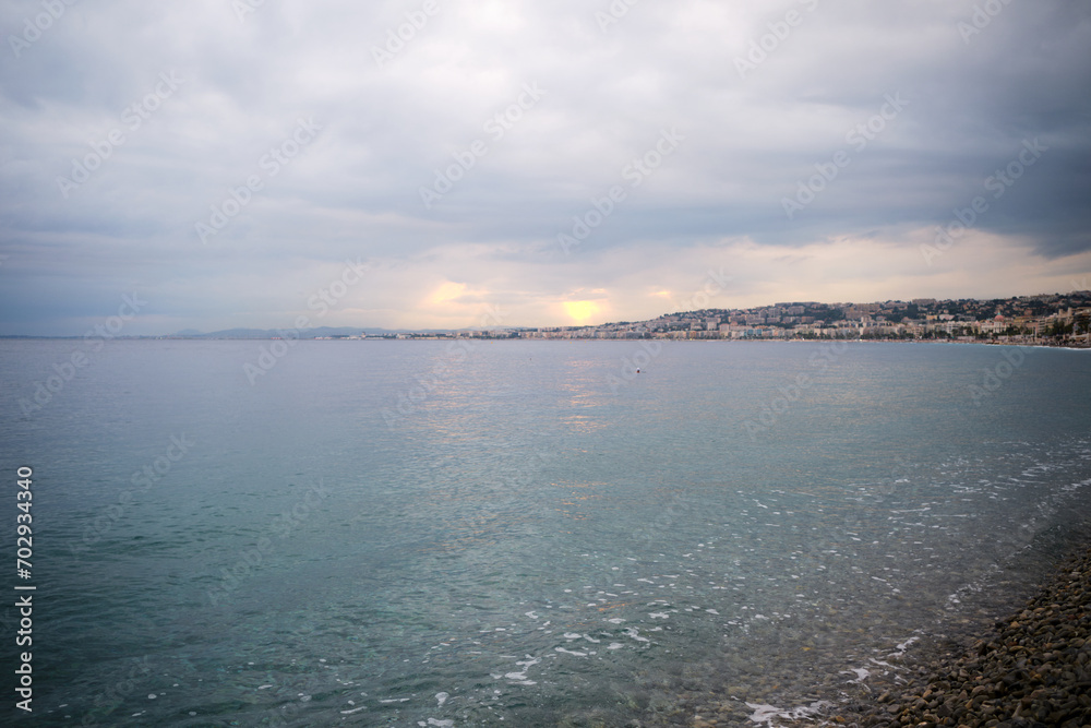 Fototapeta premium The rays of the setting sun break through the clouds over the Mediterranean Sea in Nice