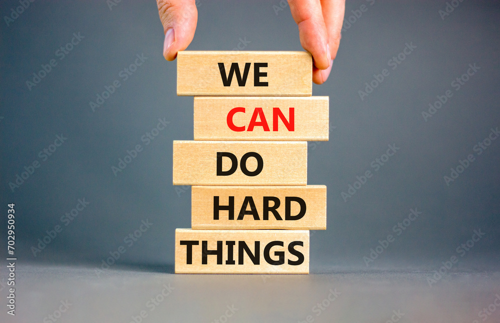 We can do hard things symbol. Concept words We can do hard things on wooden blocks. Beautiful grey table grey background. Businessman hand. Business, we can do hard things concept. Copy space. - obrazy, fototapety, plakaty 