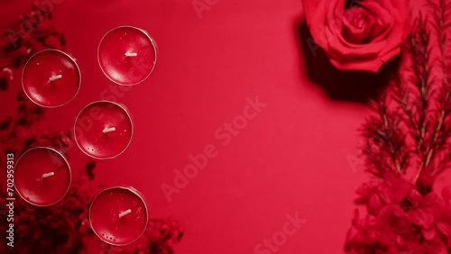 Composition of flowers, candles on pink background with water waves top view close-up. Wallpaper with flora aroma objects photo
