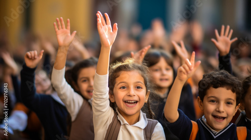 Children raising hands in a classroom © XaMaps