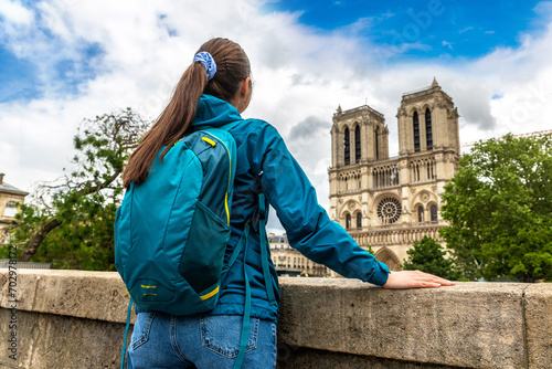 Woman traveler at Notre Dame de Paris is the one of the most famous symbols of Paris, France photo