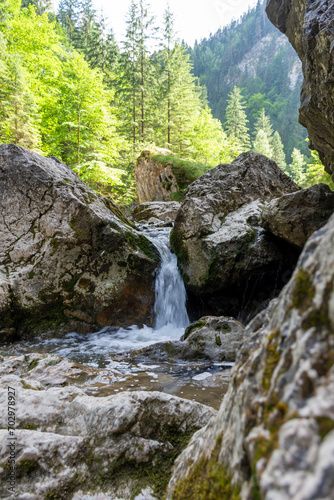 A small waterfall flows through the rocks in a mountain river