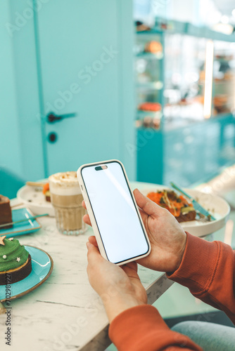Phone with isolated screen on background of food in restaurant