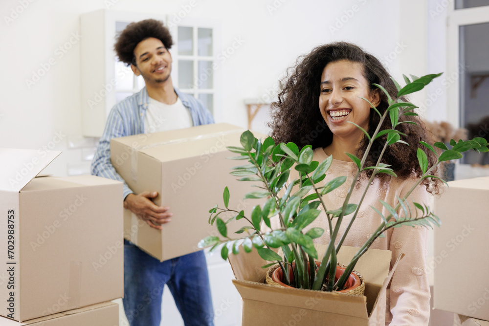 African American couple, man woman, collect clothes and plants in cardboard boxes for moving. happy young people relocating to new home. mortgage or rental of real estate. moving movers service African American couple, man woman, collect clothes and plants in cardboard boxes for moving. happy young people relocating to new home. mortgage or rental of real estate. moving movers service