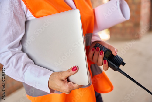 Obraz na plátně Building inspector using portable two-way radio and computer on site