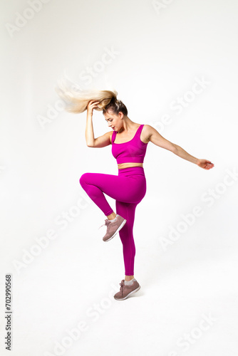 Woman in vibrant pink sports outfit hairs in air and hand holding them