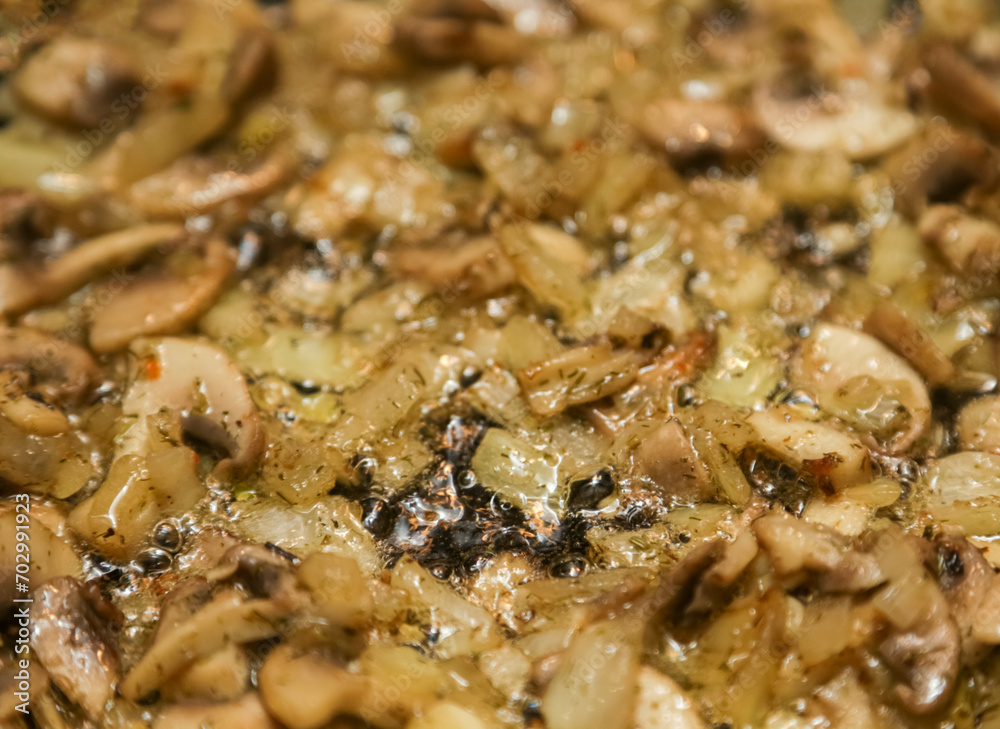 We cook mushrooms. Chopped mushrooms and golden onions in a frying pan close-up. Gastronomic background. Onions with mushrooms are fried in a frying pan. close-up, selective focus. We cook mushrooms. Chopped mushrooms and golden onions in a frying pan close-up. Gastronomic background. Onions with mushrooms are fried in a frying pan. close-up, selective focus.