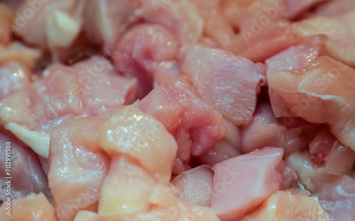 Chopped raw chicken fillet for background use. A slide of sliced raw boneless chicken breasts in close-up, background, texture.