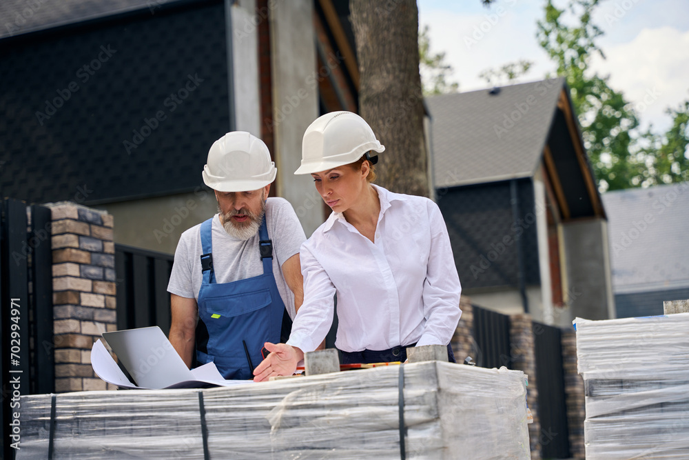 Project contractors analyzing house plans in development area