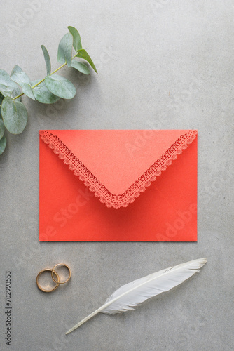 Wedding background, red invitation envelope on gray background, top view