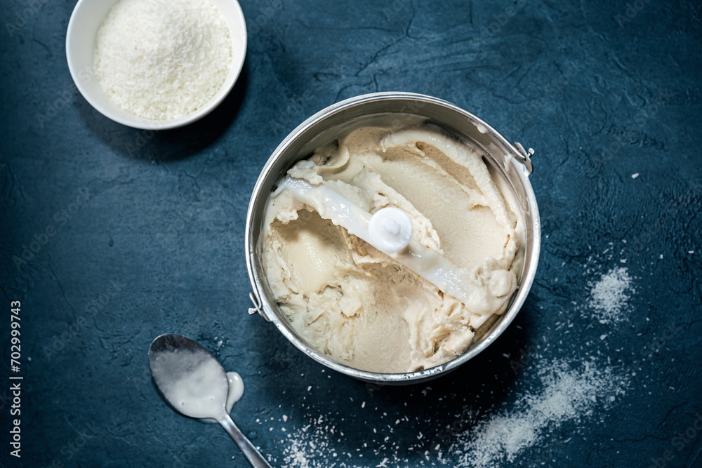 Top view of vegan coconut ice cream in bucket on blue background Top view of vegan coconut ice cream in bucket on blue background