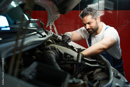 Professional car service technician is fixing his customer automobile © Viacheslav Yakobchuk