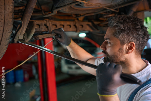 Experienced automotive service technician performing vehicle checkup
