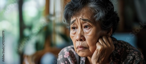 Bored elderly Asian woman deprived of companionship. photo