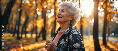 Elderly woman enjoying nature and music after a workout in the park.